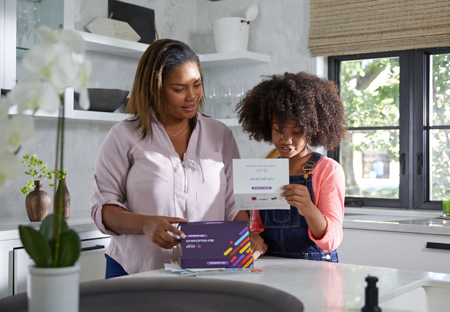 Mother and daughter open COVID-19 PCR home test.